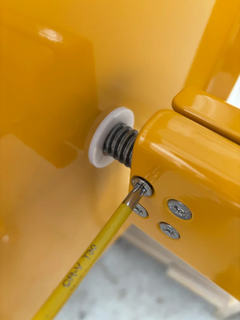 Assemblage d'un tabouret en métal jaune, fixation par visserie inox