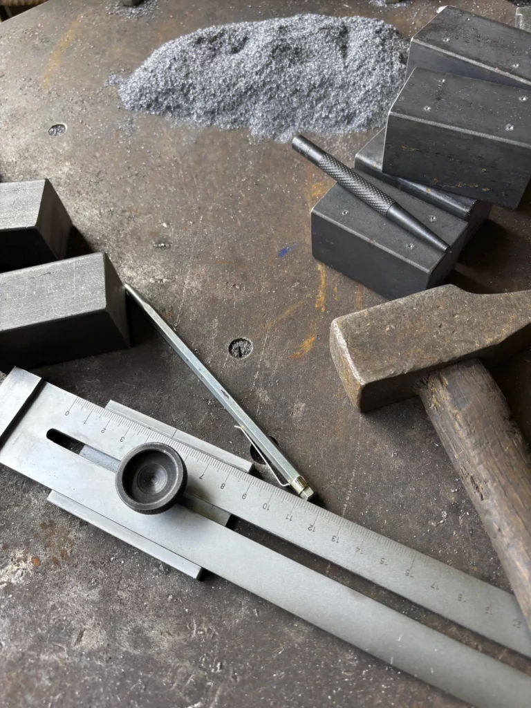 Outils de métallier : pied à coulisse, marteau et enclumes pour le façonnage sur mesure