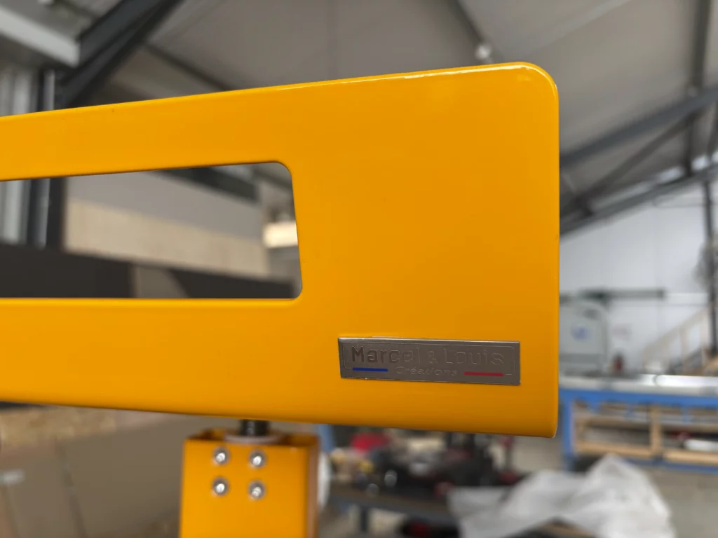 Tabouret en métal jaune avec plaque signature Marcel & Louis Créations